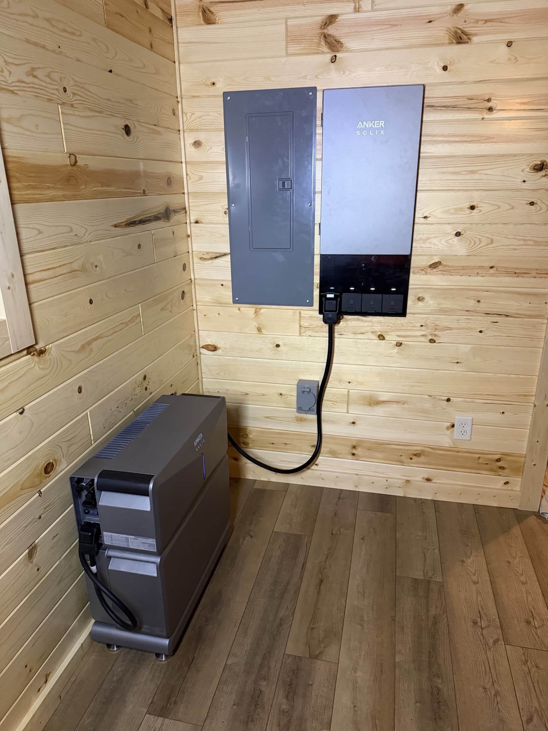 Anker SOLIX home battery system and electrical panel on a knotty pine wall