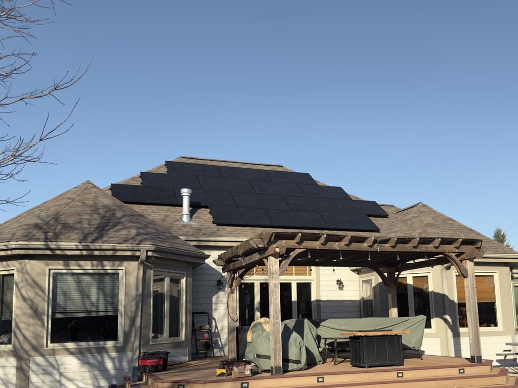 All-black solar array above the backyard pergola of a Muskego, Wisconsin home