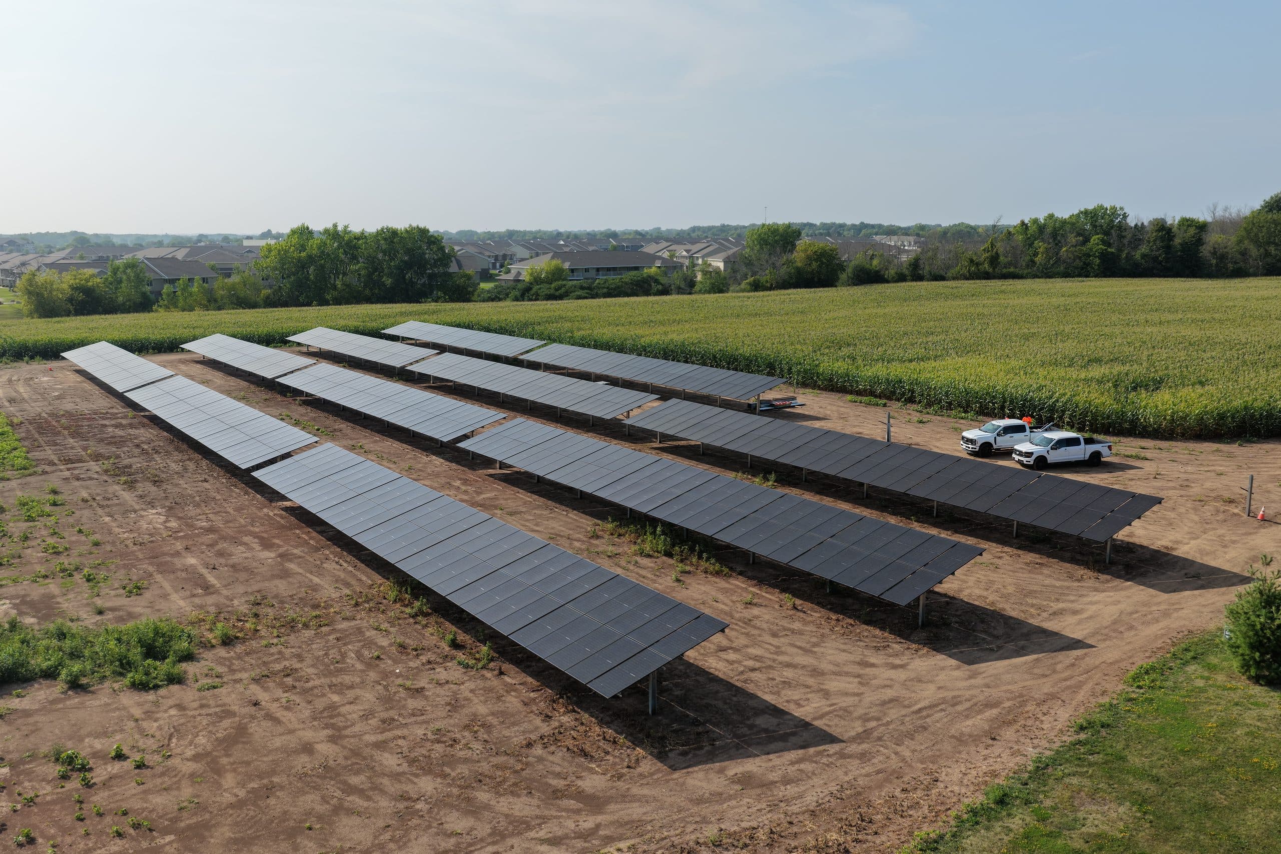 Install crew trucks beside finished rows of the ground-mounted solar array at Christ the Rock in Menasha, Wisconsin